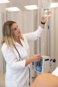 Student nurse adjusting drip for robot patient