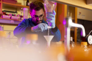 Northeastern University Pharmaceutical Sciences where a student is using funnel tool in a research lab