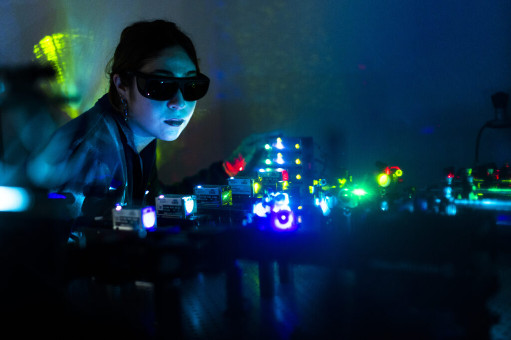 Graduate student using lasers for research at the Logothetis/Plant Lab at Northeastern University