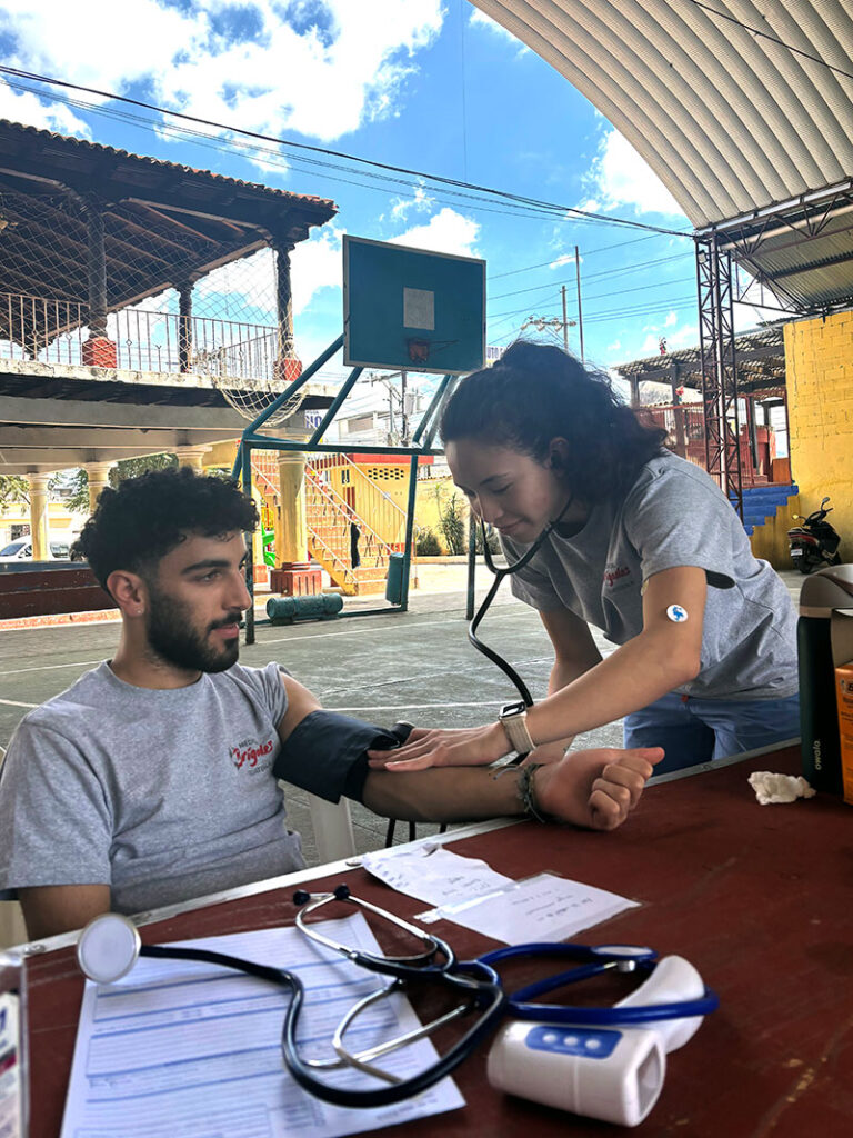 HS Student Group member giving a health checkup
