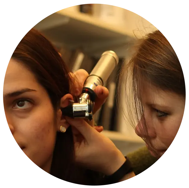 Audiologist examining patient's ears