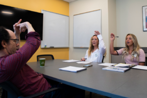 Northeastern speech language pathology graduate students Olivia Fahey and Sabrina Bender go through speech exercises with their patient Rob Jacobson