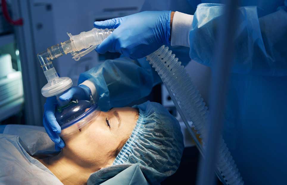 Woman being put under anesthesia in an operating room