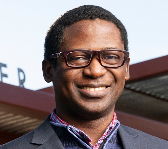 A photo of Professor John Olawepo smiling.