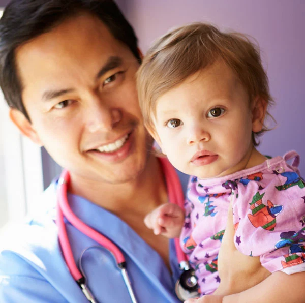 Asian male nurse smiling with baby