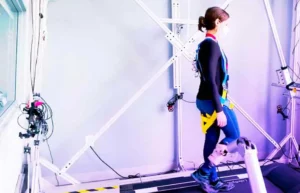 CJ Hasson Lab woman's movement being tracked and guided by a robotic arm to correct her movement