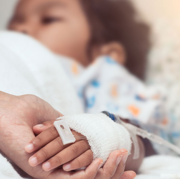 Nurse holds hand of little sick girl