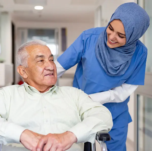 Nurse in headscarf caring for elderly man