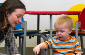 Speech-language pathologist working with a small child through play