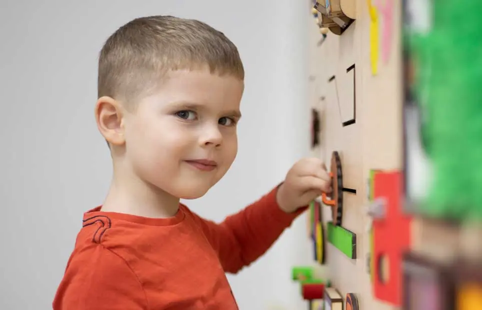 Little boy playing with wall puzzle