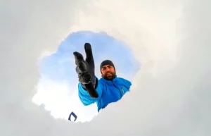 Man reaching in to rescue individuals from snow drift