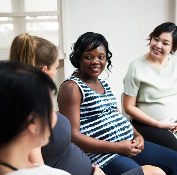 Pregnant women from different ethnicity sitting in a doctor's office
