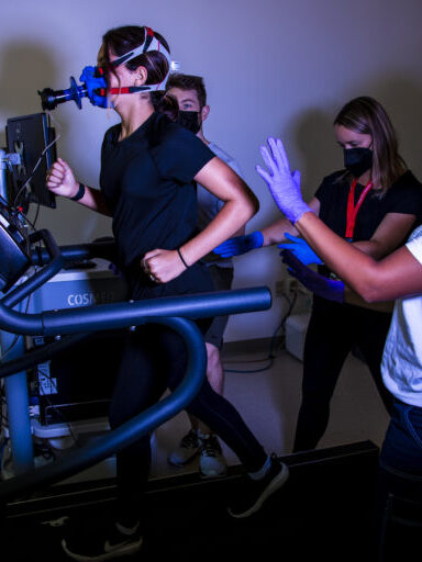 Northeastern Psychology student Trevor Cline runs a simulation with Mattea, 13, where she runs on a treadmill