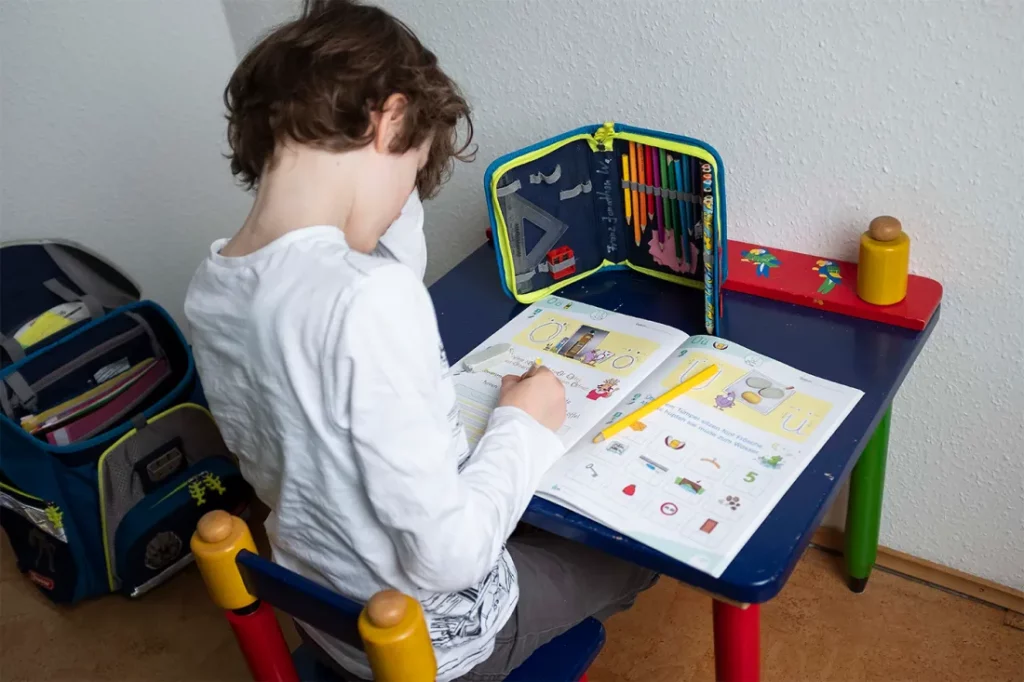 Erstklaessler, 7, sits at a table at home and does tasks in his booklet “Alphabet booklet – basic font”, on May 4, 2020. Photo by Anke Waelischmiller/SVEN SIMON/picture-alliance/dpa/AP Images
