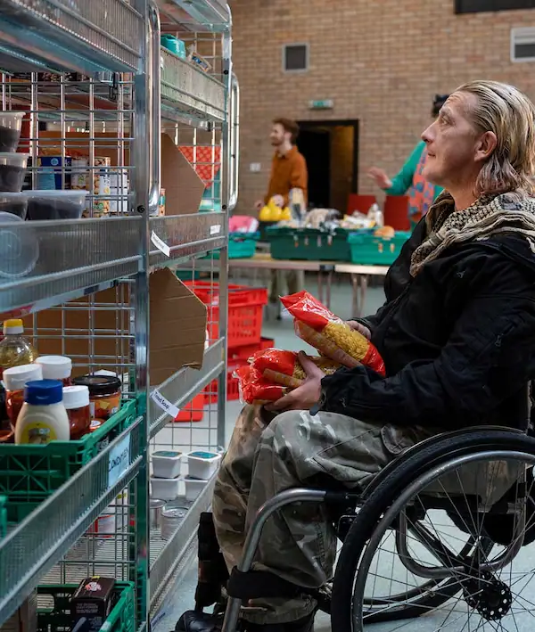 Man in wheelchair searching shelves at a food bank