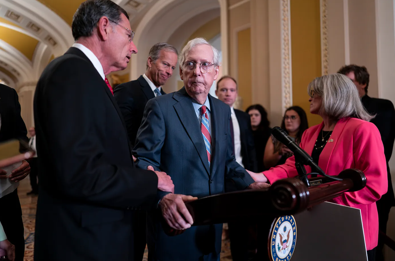 Senate Minority Leader Mitch McConnell is helped after the 81-year-old GOP leader froze at the microphones as he arrived for a news conference.