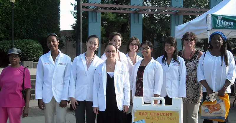 A group of pharmacy co-op students in their white coats