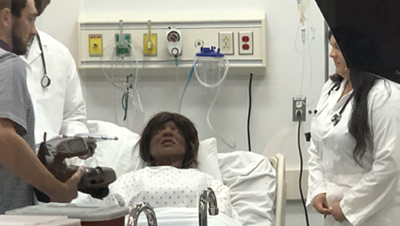 Group standing around a SIM patient of color for a photoshoot