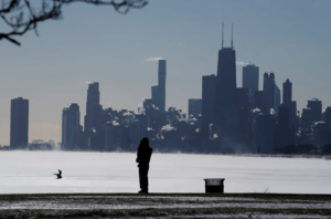 A woman bundles up as she looks to the Lake Michigan at Montrose beach in Chicago. Millions of Americans face below-zero temperatures as storms bring blast of Arctic air, snow and ice, raising the risk of hypothermia and frostbite. AP Photo/Nam Y. Huh