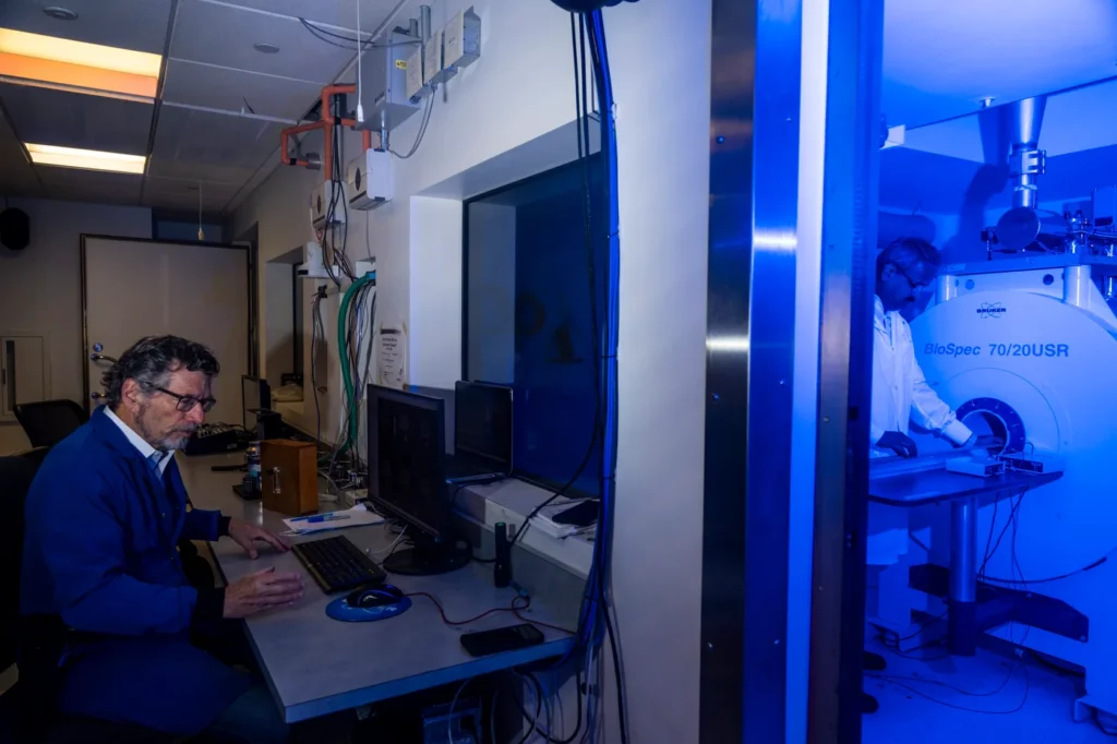 Professor of psychology and pharmaceutical sciences Craig Ferris and principal research engineer Praveen Kulkarni work with the MRI machine. Photo by Alyssa Stone/Northeastern University