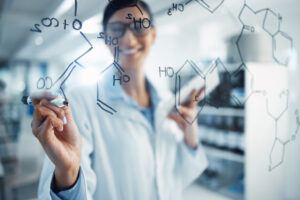 Shot of a young scientist solving equations on a glass screen in a laboratory