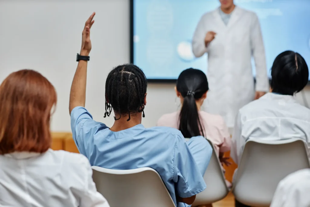 Public Health student raises hand during class.