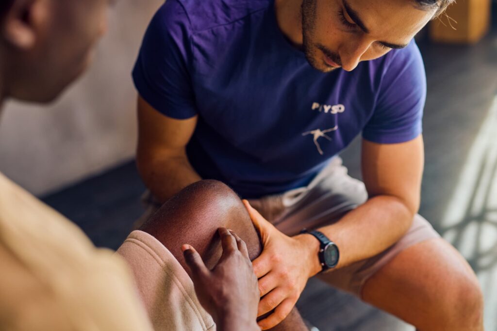 A specialist observing a patient's injured leg.