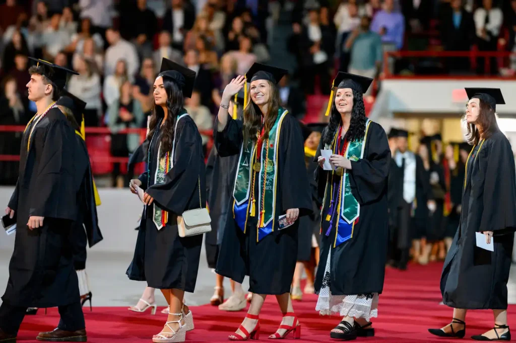 Graduates waving to families in the crowd at the Bouvé College Celebration