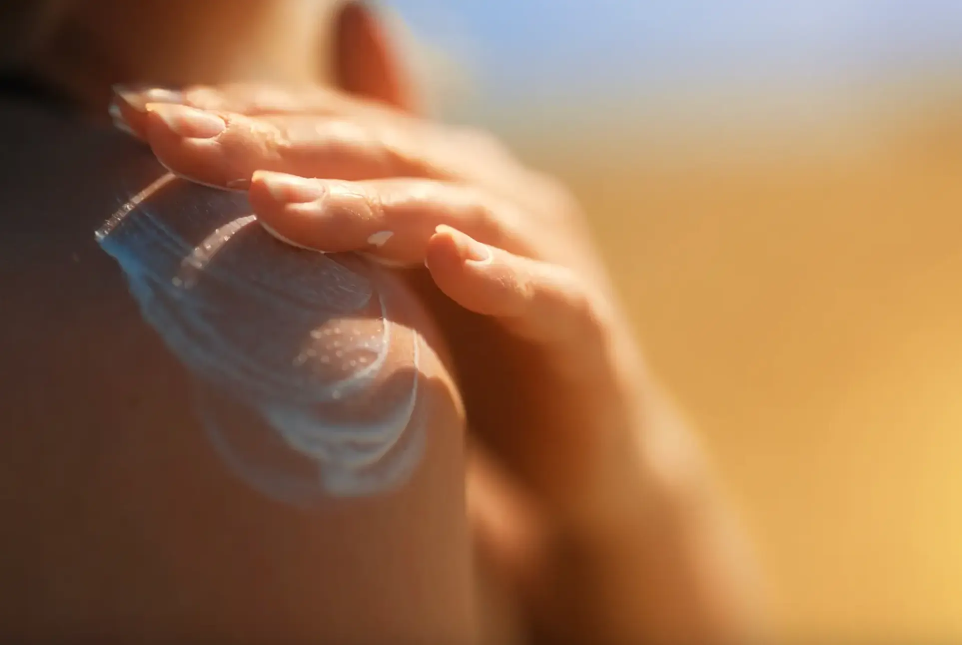 Photo of a person applying sunscreen to their shoulder.