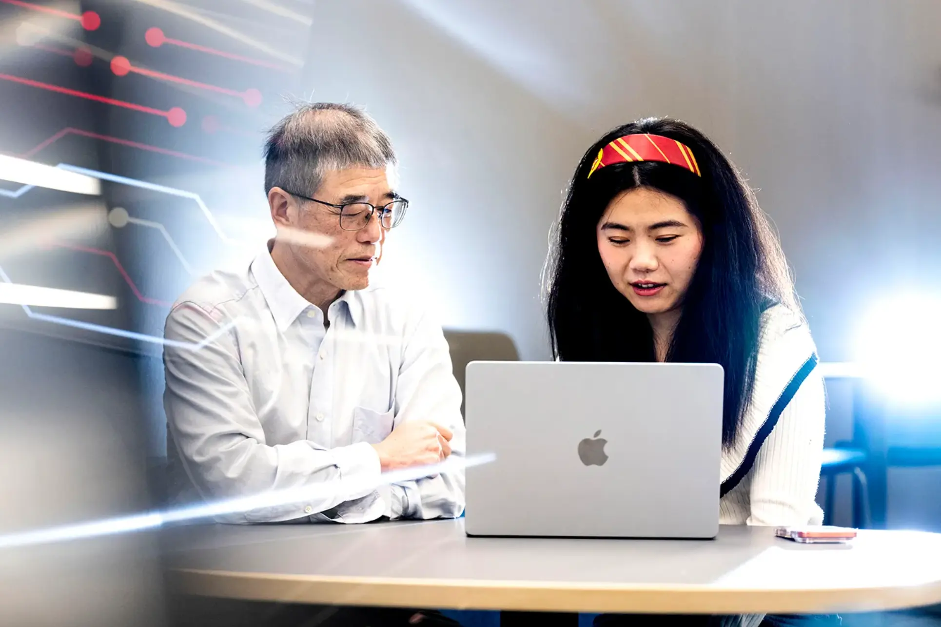 Northeastern University professor Lei Xie and researcher You Wu (right) sit in front of a Mac laptop going over their new research.
