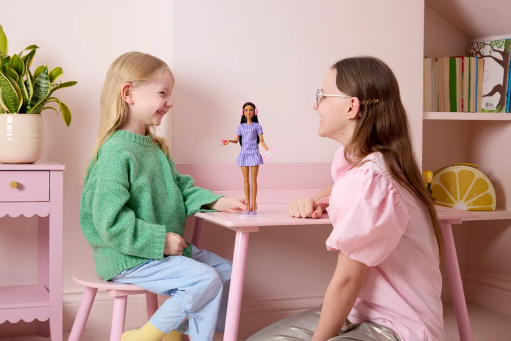 Photo of two girls playing with a Barbie doll