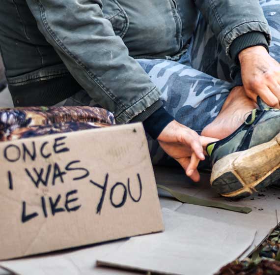Once I was like you — sign beside homeless man