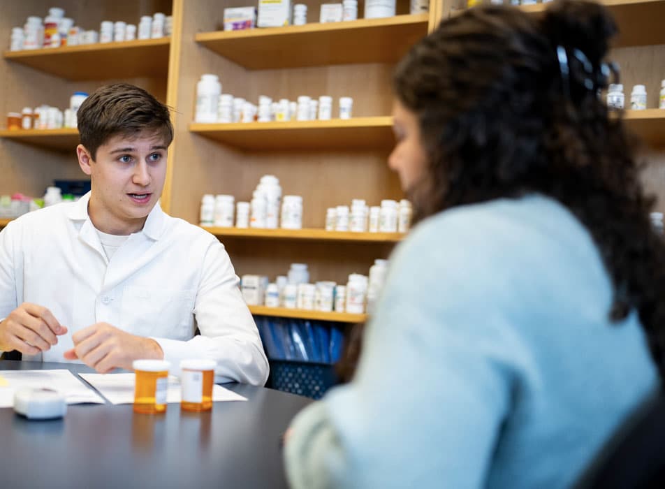 Pharmacy skills lab — two student role-playing