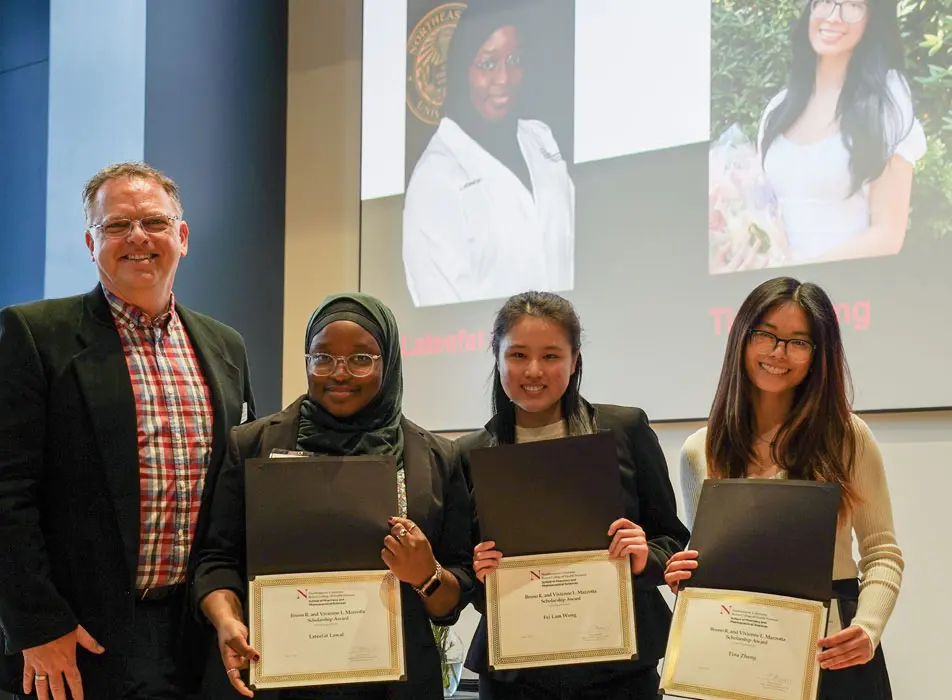 Professor and students smiling and showing their awards certificates at the School of Pharmacy and Pharmaceutical Sciences Award Ceremony